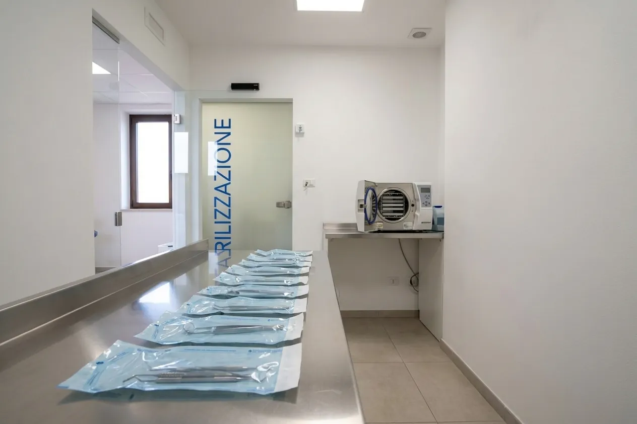 Le buste sigillate di strumenti sterili e l'autoclave nella sala di sterilizzazione dello studio di Ghezzano