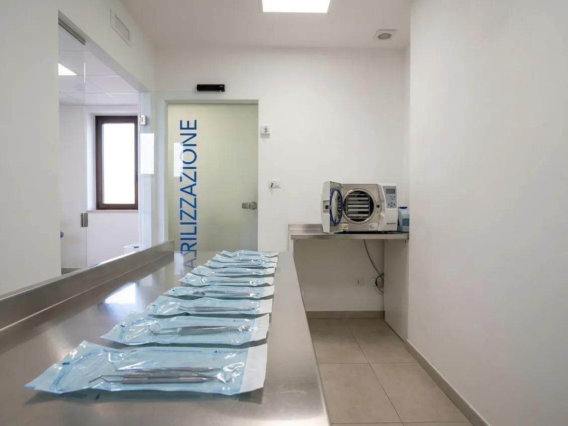 Le buste sigillate di strumenti sterili e l'autoclave nella sala di sterilizzazione dello studio di Ghezzano