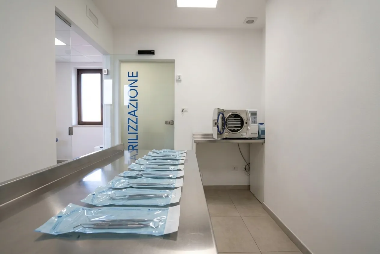 Le buste sigillate di strumenti sterili e l'autoclave nella sala di sterilizzazione dello studio di Ghezzano